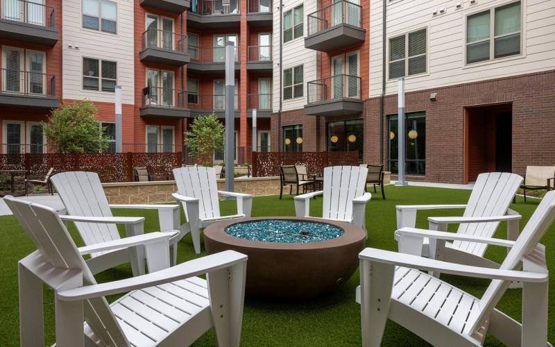 a courtyard with chairs and a fire pit